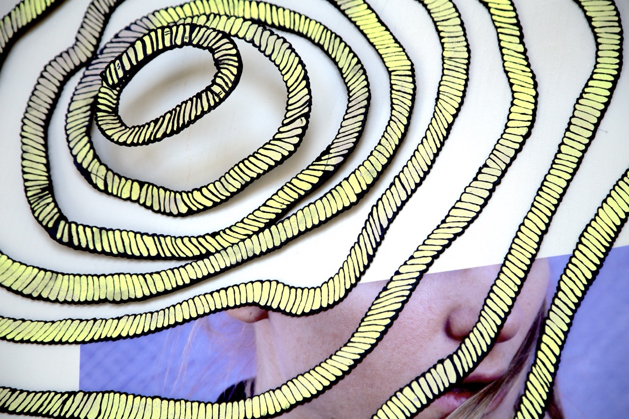 fake rope, coiled on a platform, partially covering an image of a woman